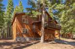 Nestled among tall pine trees, this charming wooden cabin offers a rustic retreat with a stone foundation and multiple levels of living space.