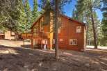 Nestled amidst tall pine trees, this charming wooden home offers a serene mountain retreat.