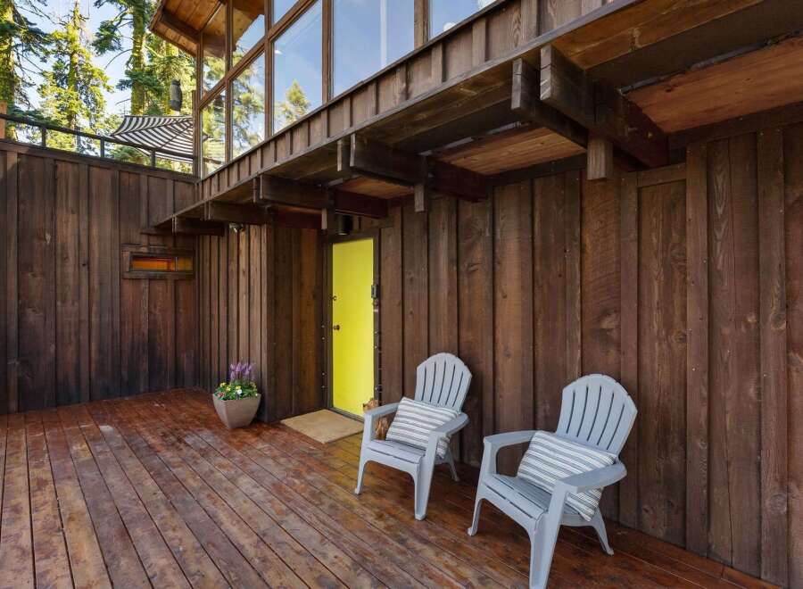 Step onto the rustic wooden deck of this charming home, perfect for enjoying the serene natural surroundings.