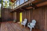 Step onto the rustic wooden deck of this charming home, perfect for enjoying the serene natural surroundings.