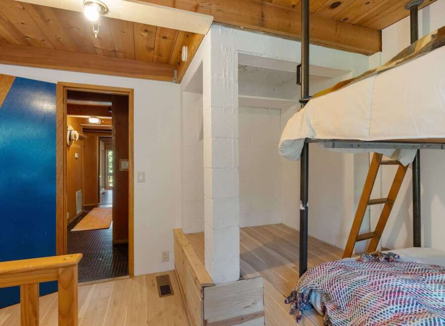 Discover this unique loft-style bedroom featuring a cozy bunk bed setup with a ladder for access.