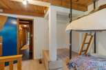 Discover this unique loft-style bedroom featuring a cozy bunk bed setup with a ladder for access.