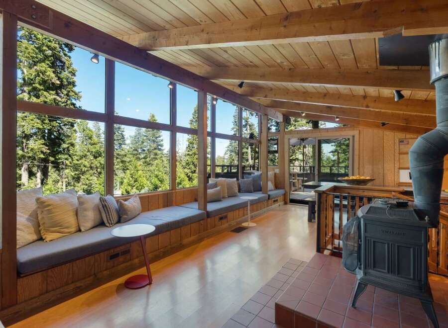 Experience breathtaking forest views from this stunning living space, featuring a wall of windows that floods the room with natural light.