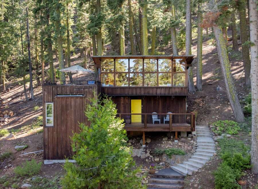Nestled amongst towering trees, this unique mountain home offers a serene escape with its striking modern architecture.