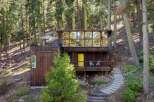Nestled amongst towering trees, this unique mountain home offers a serene escape with its striking modern architecture.