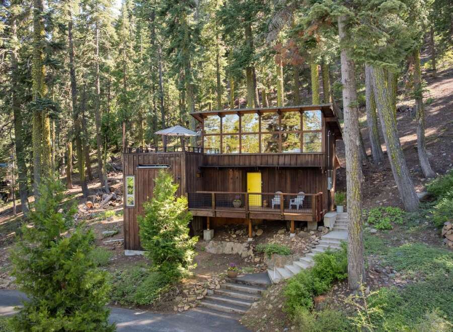 Nestled amidst towering trees, this unique modern cabin offers a serene retreat.
