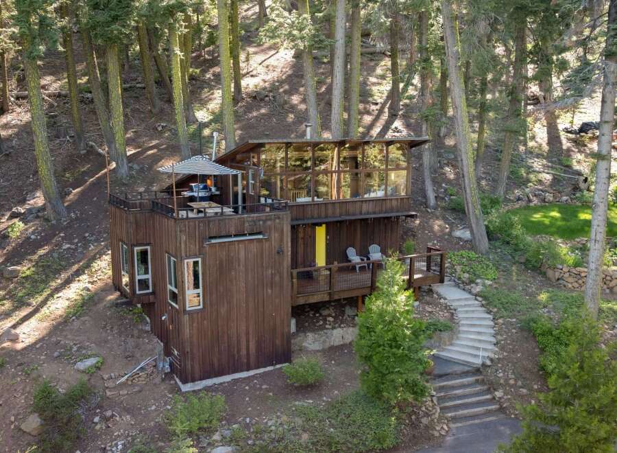 Nestled amidst a serene forest, this unique multi-level home offers a blend of modern design and natural charm.