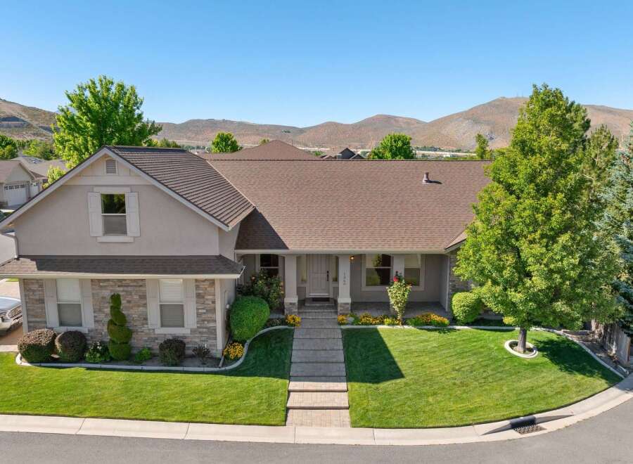 Discover this stunning single-family home featuring a beautifully manicured lawn and a welcoming front porch.