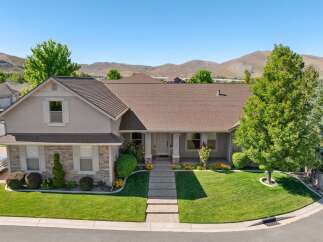 Discover this stunning single-family home featuring a beautifully manicured lawn and a welcoming front porch.