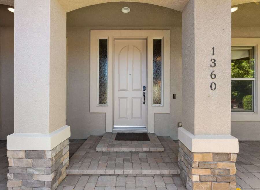 Welcome to this charming home featuring a beautiful arched entryway with decorative sidelights framing the elegant front door.
