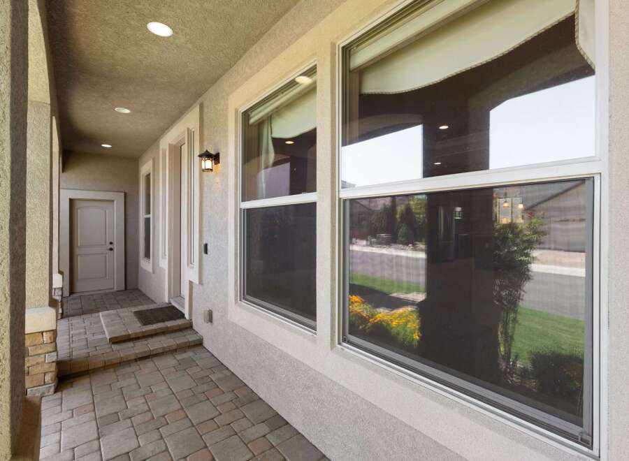 Welcome guests to this charming home with a covered front porch featuring a paved walkway and steps leading to the front door.