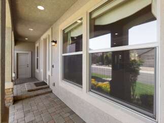 Welcome guests to this charming home with a covered front porch featuring a paved walkway and steps leading to the front door.