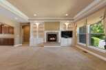 This spacious living room features a cozy fireplace with built-in shelving and a large television, perfect for entertaining.