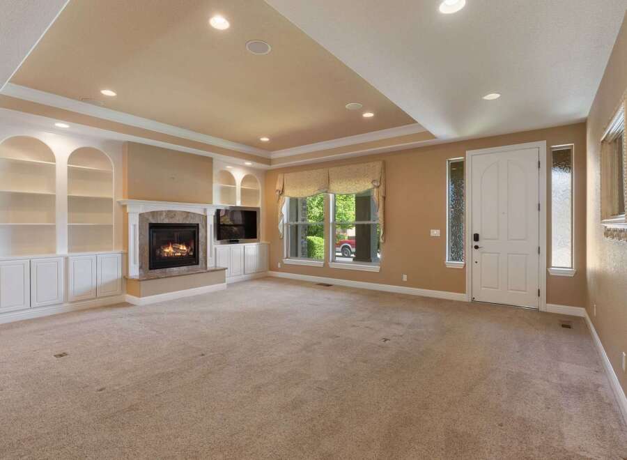 Step into this inviting living room featuring a cozy fireplace and built-in shelving, perfect for displaying your favorite items.