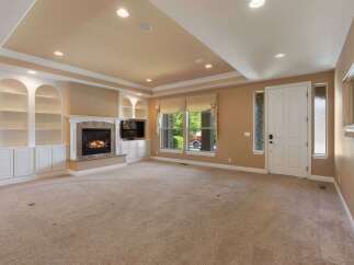 Step into this inviting living room featuring a cozy fireplace and built-in shelving, perfect for displaying your favorite items.