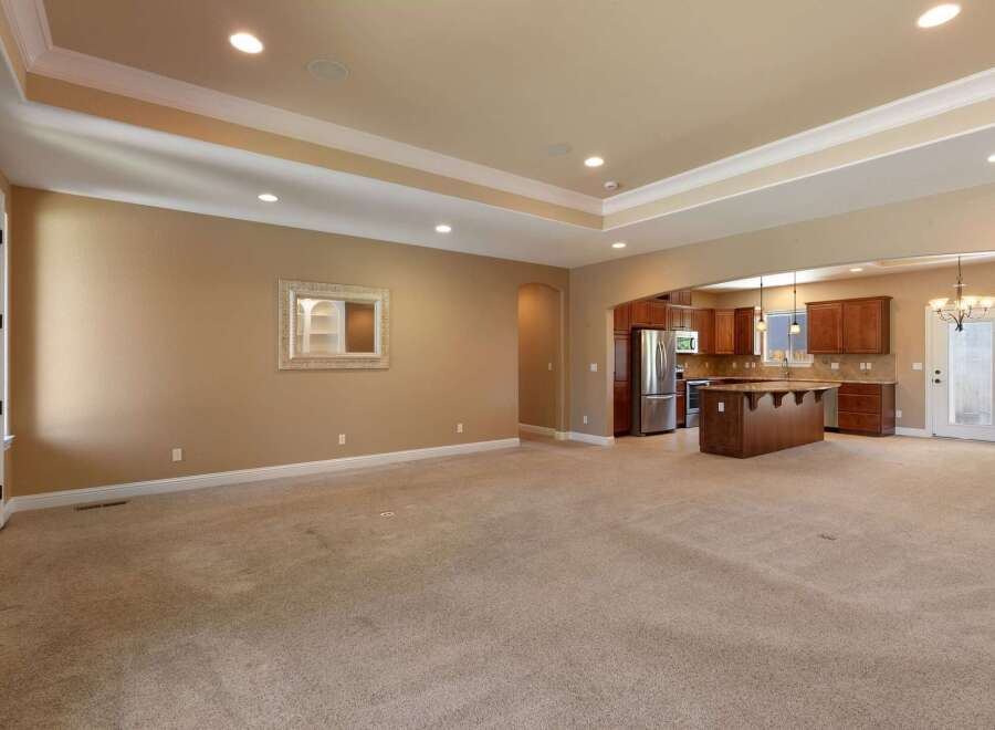 This spacious open-concept living area seamlessly connects to a modern kitchen, perfect for entertaining.