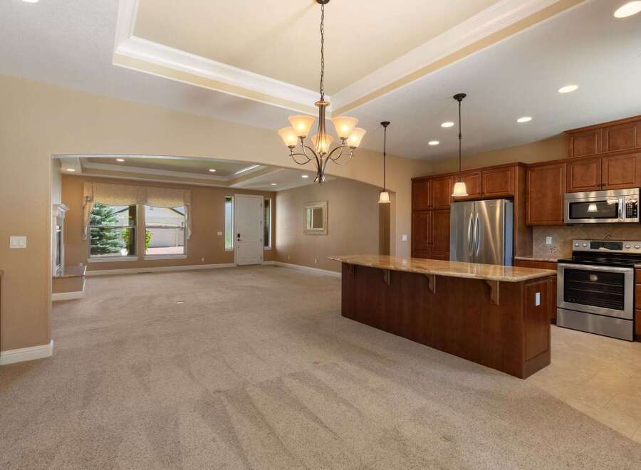 Experience open-concept living in this spacious home, featuring a large kitchen island perfect for entertaining and a bright, airy living area with a cozy fireplace.