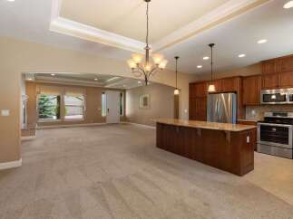 Experience open-concept living in this spacious home, featuring a large kitchen island perfect for entertaining and a bright, airy living area with a cozy fireplace.