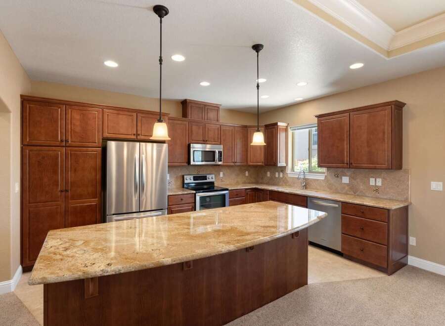 Experience luxury in this stunning kitchen featuring rich cherry wood cabinetry and a spacious granite island perfect for entertaining.