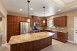Experience luxury in this stunning kitchen featuring rich cherry wood cabinetry and a spacious granite island perfect for entertaining.