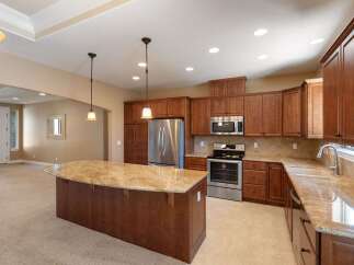 This spacious kitchen boasts rich cherry wood cabinetry and elegant granite countertops, perfect for the home chef.