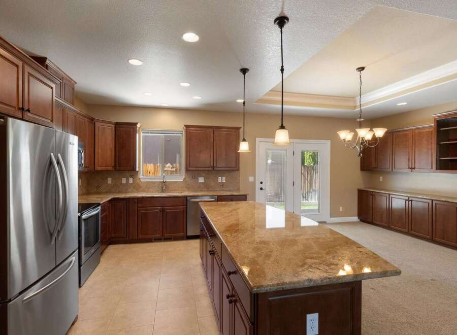 Experience culinary excellence in this spacious kitchen, featuring rich cherry wood cabinetry and elegant granite countertops.