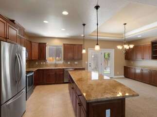 Experience culinary excellence in this spacious kitchen, featuring rich cherry wood cabinetry and elegant granite countertops.
