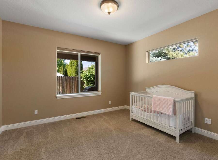 This charming nursery features a cozy crib adorned with a soft pink blanket, perfect for a little one.