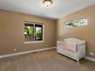 This charming nursery features a cozy crib adorned with a soft pink blanket, perfect for a little one.