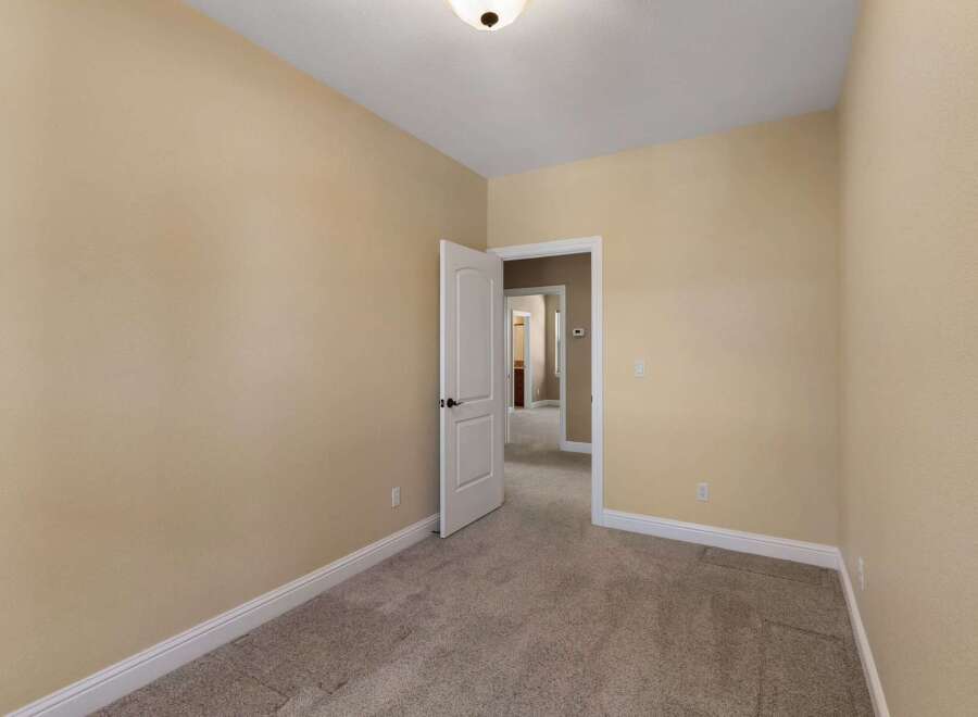 Step into this inviting room featuring neutral beige walls and plush carpeting, creating a warm and welcoming atmosphere.