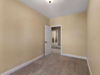 Step into this inviting room featuring neutral beige walls and plush carpeting, creating a warm and welcoming atmosphere.