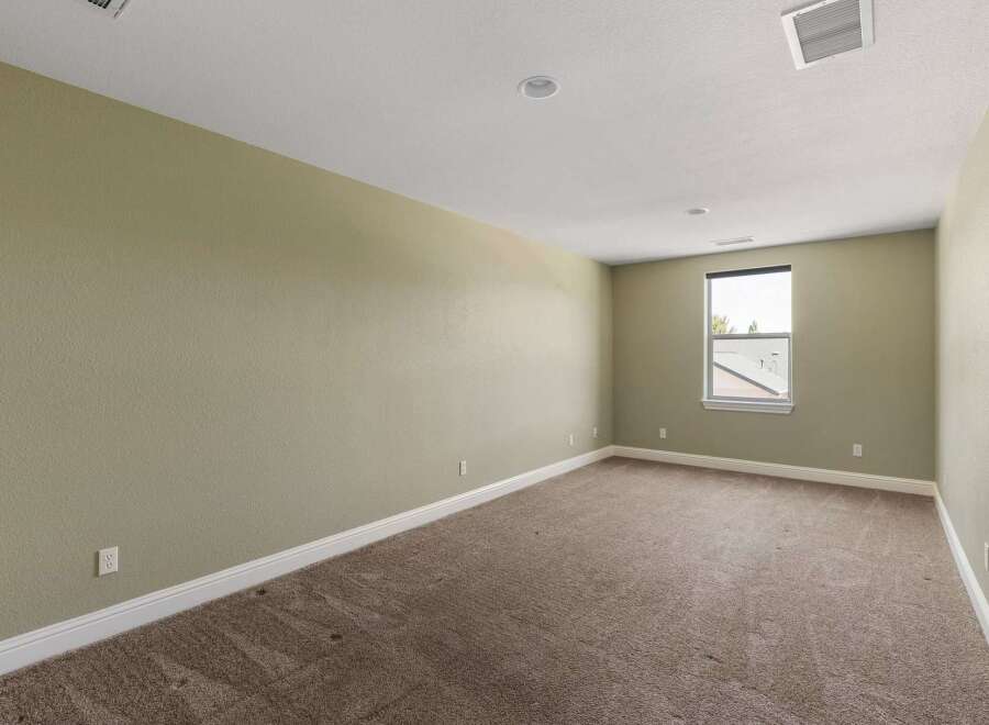 This spacious room features neutral-toned walls and plush carpeting, creating a serene and inviting atmosphere.