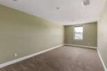 This spacious room features neutral-toned walls and plush carpeting, creating a serene and inviting atmosphere.