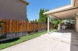 Enjoy outdoor living in this spacious backyard featuring a covered patio perfect for entertaining.