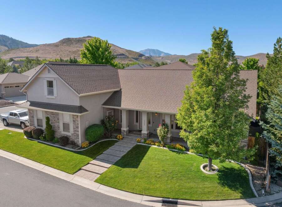 Discover this stunning home featuring a beautifully manicured lawn and a welcoming front porch with stately columns.