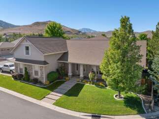 Discover this stunning home featuring a beautifully manicured lawn and a welcoming front porch with stately columns.