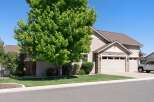 Discover this charming home featuring a lush green lawn and a mature tree providing ample shade.