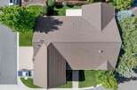 Discover this stunning aerial view of a well-maintained home featuring a durable brown shingle roof.