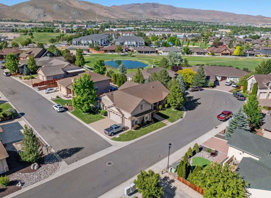 Discover this stunning aerial view of a suburban neighborhood, showcasing beautiful homes with well-maintained lawns and mature trees.