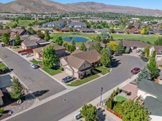 Discover this stunning aerial view of a suburban neighborhood, showcasing beautiful homes with well-maintained lawns and mature trees.