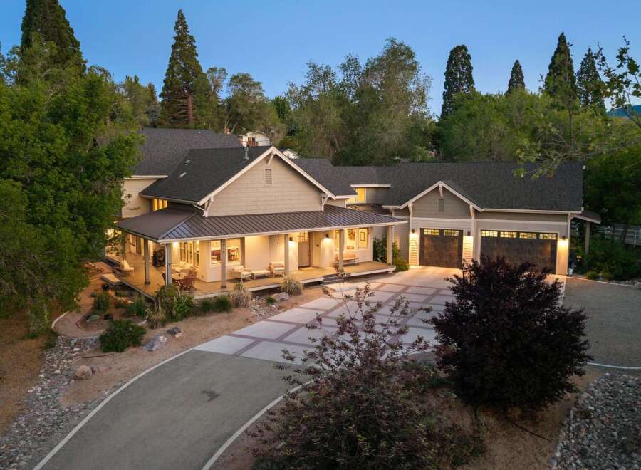 Discover this stunning home featuring a welcoming covered porch with ample seating, perfect for enjoying the serene surroundings.