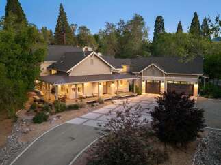 Discover this stunning home featuring a welcoming covered porch with ample seating, perfect for enjoying the serene surroundings.