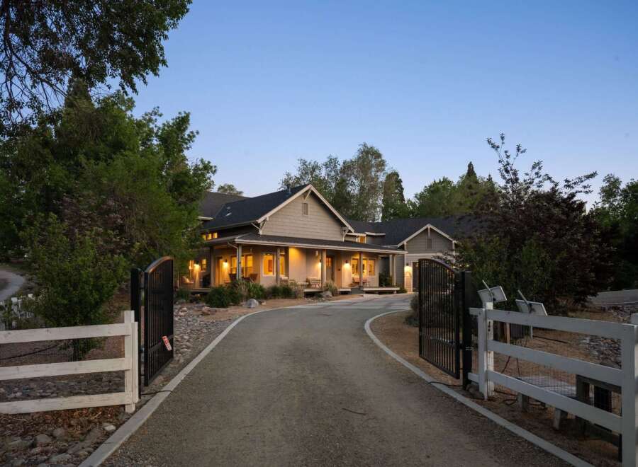Discover this stunning property featuring a charming farmhouse-style home with a welcoming wrap-around porch, perfect for enjoying the serene surroundings.