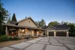 This stunning home features a welcoming covered porch with ample seating, perfect for enjoying the outdoors.