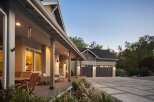This stunning home features a welcoming covered porch with comfortable seating and a dining area, perfect for enjoying the outdoors.