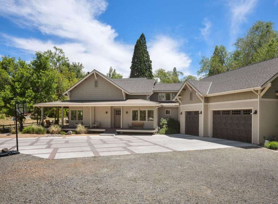 Discover this stunning home featuring a welcoming covered porch and a spacious driveway with a basketball hoop.