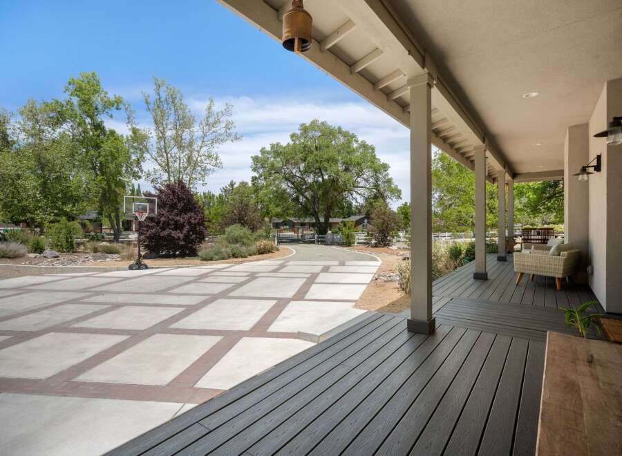 Enjoy outdoor living with this spacious property featuring a large paved driveway and a basketball hoop for recreation.