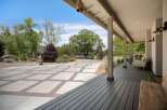 Enjoy outdoor living with this spacious property featuring a large paved driveway and a basketball hoop for recreation.