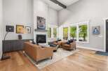 Experience luxury living in this stunning great room, featuring a soaring vaulted ceiling with exposed beams and a modern fireplace as the focal point.