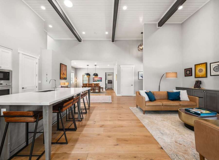 Experience modern living in this spacious open-concept home, featuring a gourmet kitchen with a large island and bar seating, flowing seamlessly into a bright living area.